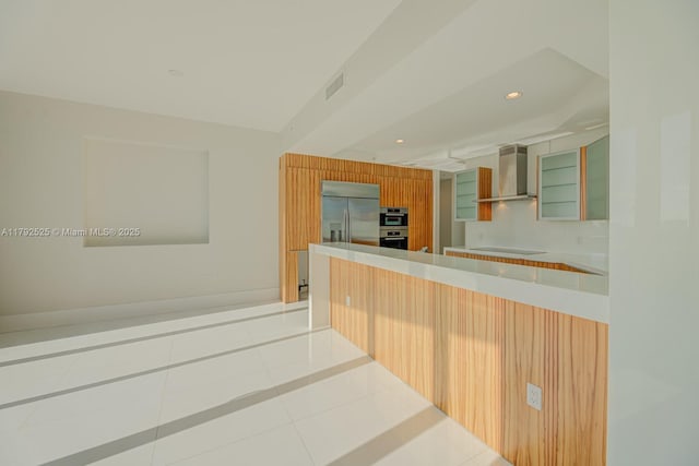 kitchen featuring wall chimney exhaust hood, recessed lighting, stainless steel appliances, light tile patterned floors, and visible vents