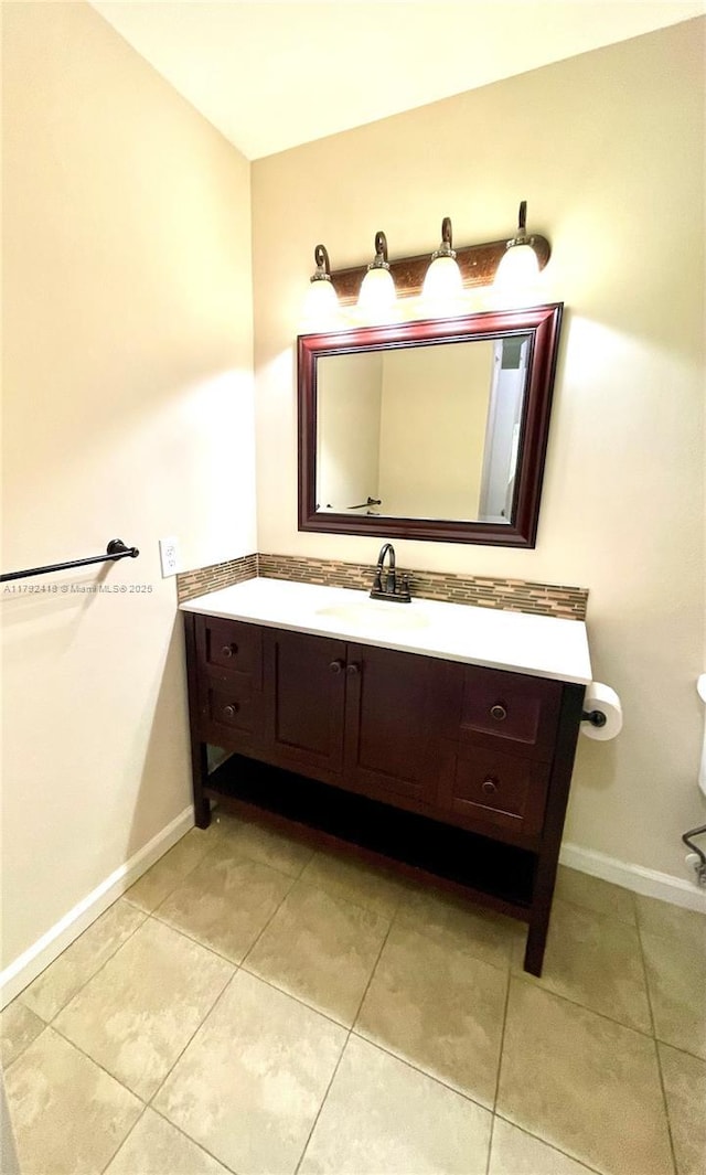 bathroom with vanity, baseboards, and tile patterned floors