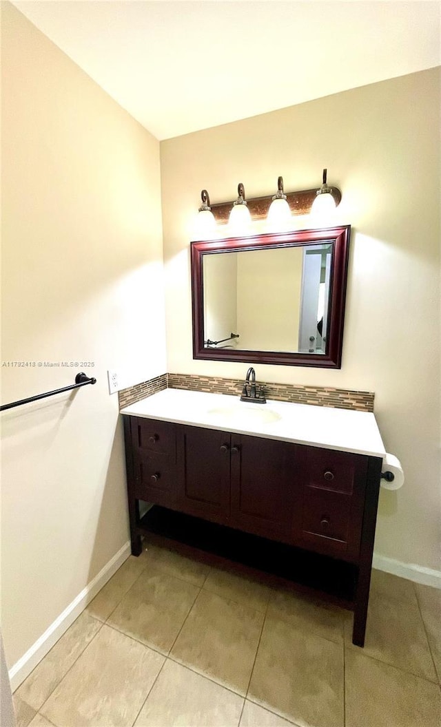 bathroom with baseboards, vanity, and tile patterned floors