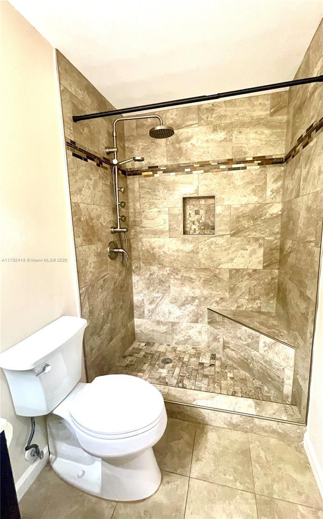 full bath with a tile shower and toilet