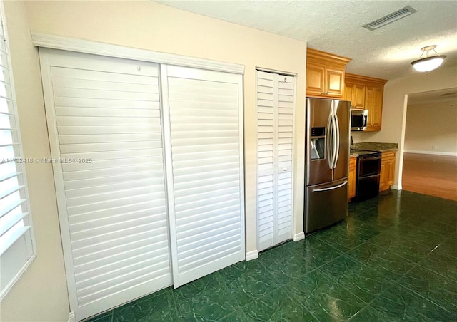 kitchen with baseboards, appliances with stainless steel finishes, and visible vents