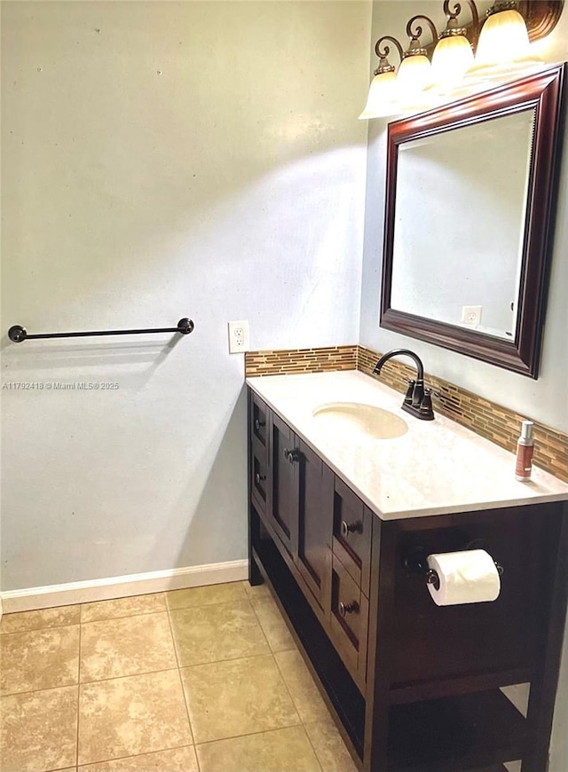 bathroom featuring vanity, decorative backsplash, baseboards, and tile patterned flooring