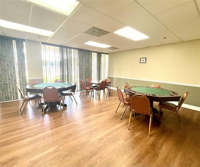 playroom with baseboards, light wood-type flooring, and a paneled ceiling