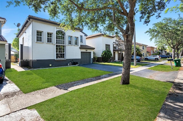 view of front of house with an attached garage, driveway, stucco siding, and a front yard