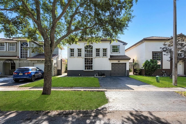 traditional home with a garage, stucco siding, a front lawn, and aphalt driveway