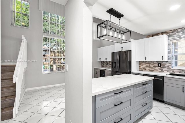 kitchen with gray cabinetry, light tile patterned floors, dishwashing machine, and black fridge with ice dispenser