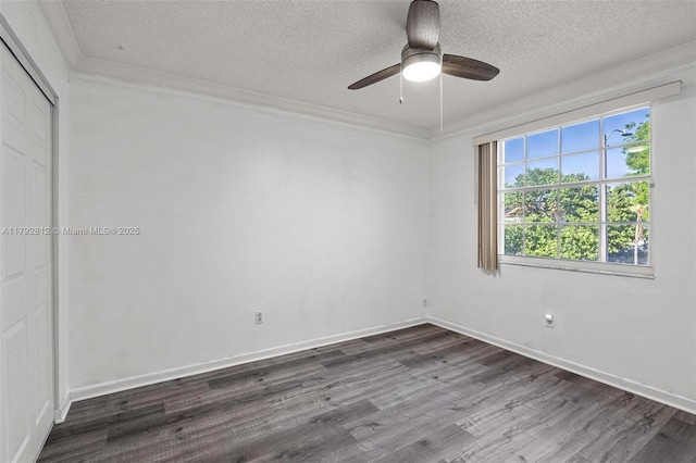 unfurnished bedroom featuring a closet, ornamental molding, dark wood-type flooring, a textured ceiling, and a ceiling fan