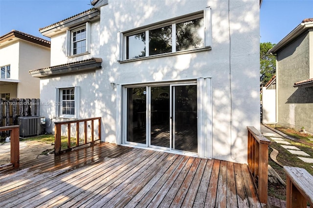 back of house with central air condition unit, stucco siding, a wooden deck, and fence