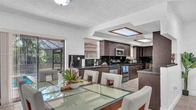 19241 SW 93rd Rd, Cutler Bay, FL 33157 - dining space featuring light tile patterned flooring, baseboards, a textured ceiling, and a raised ceiling
