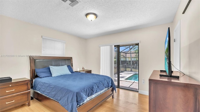 bedroom with visible vents, a textured ceiling, light wood-style flooring, and access to exterior