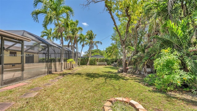 view of yard with a fenced backyard and a lanai
