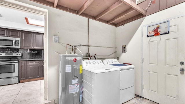 washroom featuring light tile patterned floors, laundry area, washing machine and dryer, and electric water heater