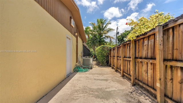 19241 SW 93rd Rd, Cutler Bay, FL 33157 - view of side of home with stucco siding, cooling unit, fence, and a patio
