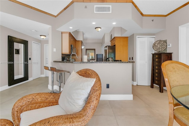 kitchen with visible vents, ornamental molding, baseboards, and stainless steel appliances