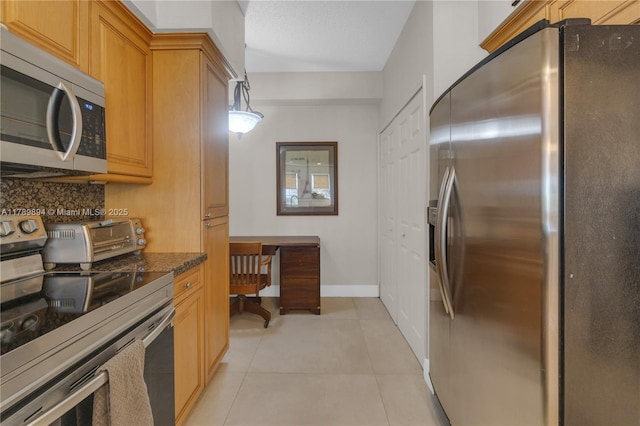 kitchen with light tile patterned flooring, appliances with stainless steel finishes, baseboards, decorative backsplash, and a toaster