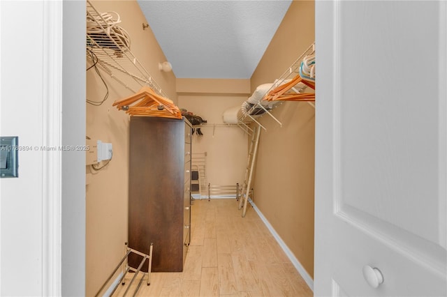 spacious closet featuring light wood-style flooring