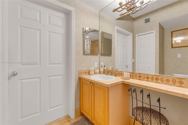 bathroom featuring visible vents, a notable chandelier, and vanity