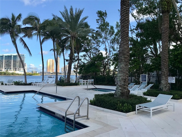 pool with a patio and a water view