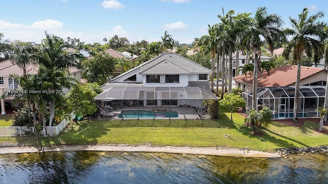 back of property with a water view, a yard, and an outdoor pool