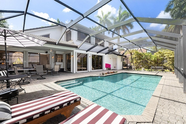 outdoor pool featuring glass enclosure and a patio area