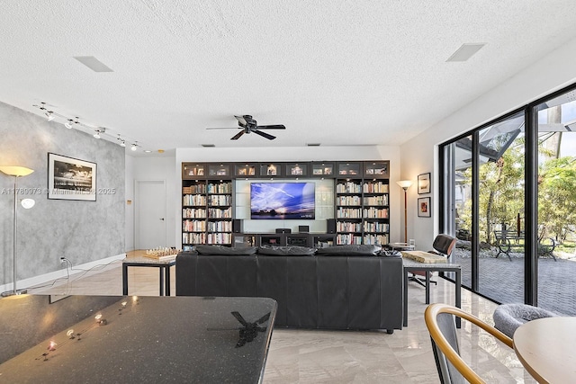 living area featuring a ceiling fan, a textured ceiling, marble finish floor, and rail lighting