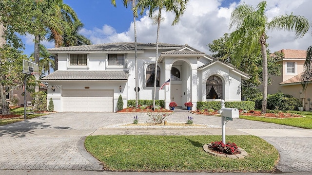 view of front of property with an attached garage, decorative driveway, stucco siding, and a tiled roof