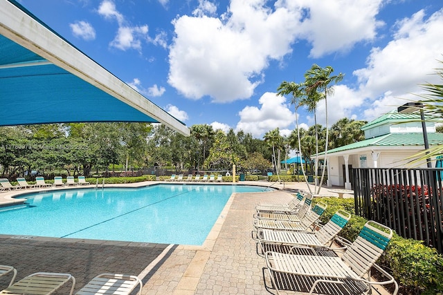 pool featuring fence and a patio area