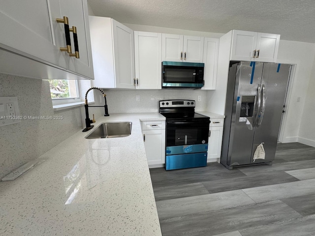 kitchen featuring a sink, light stone countertops, white cabinetry, stainless steel fridge with ice dispenser, and electric stove