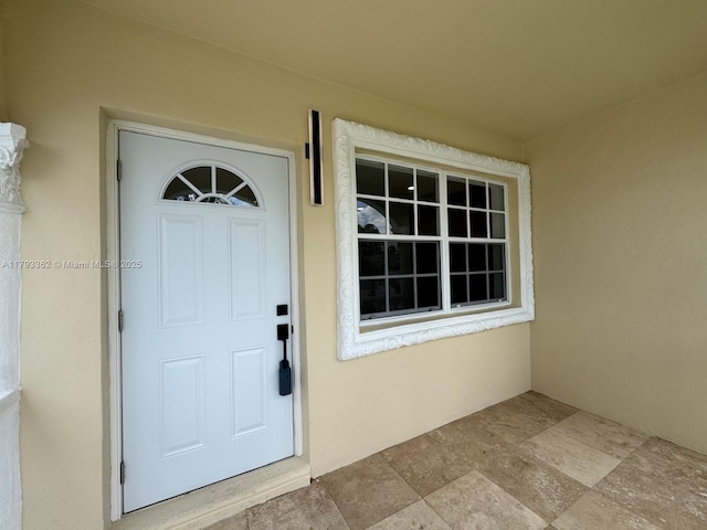 property entrance with stucco siding