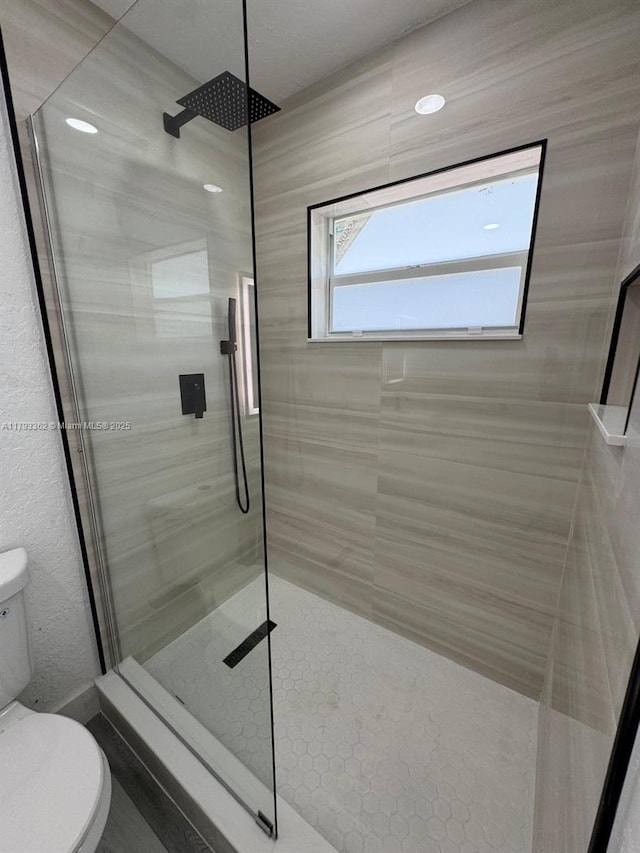 bathroom featuring a walk in shower and toilet
