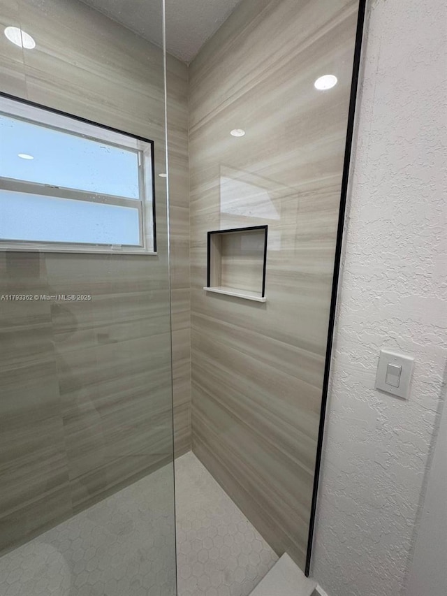 bathroom with a walk in shower and a textured wall