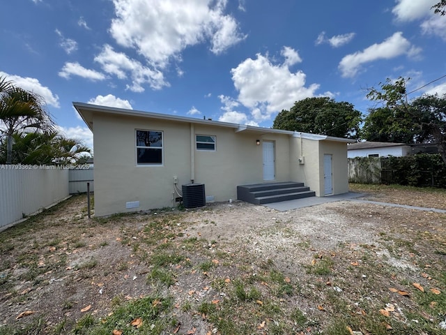 back of property with a fenced backyard, stucco siding, crawl space, and cooling unit