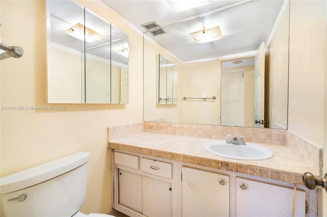 bathroom with vanity, toilet, and visible vents