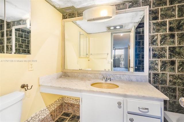 bathroom with toilet, visible vents, and vanity