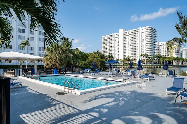 pool featuring fence, a gazebo, and a patio area