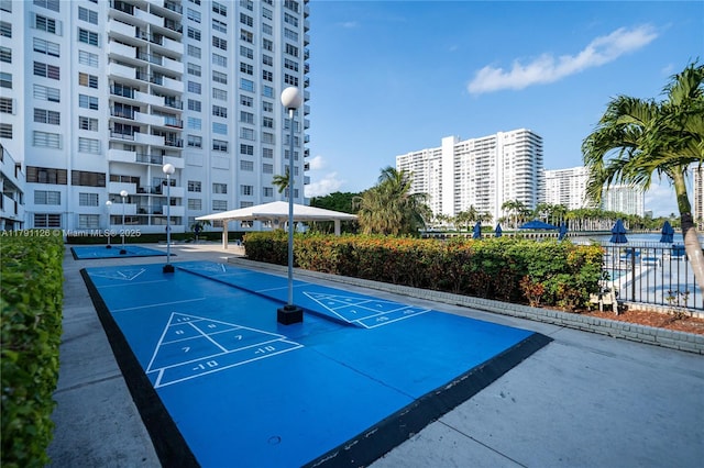view of community featuring shuffleboard and fence