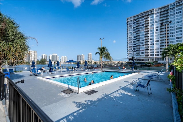 community pool with fence and a patio area