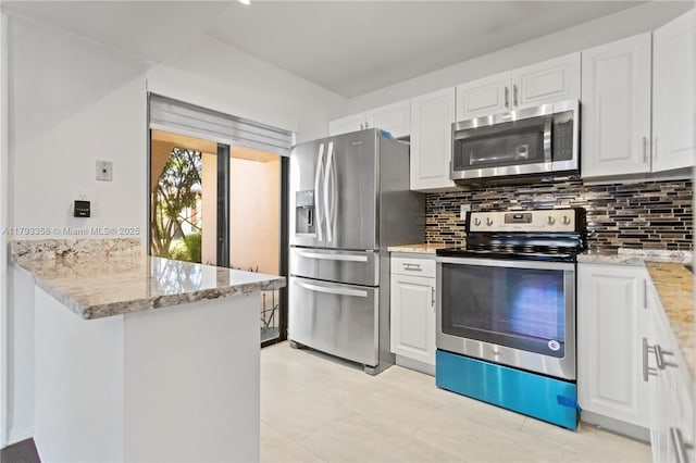 kitchen with white cabinets, light stone countertops, appliances with stainless steel finishes, a peninsula, and decorative backsplash