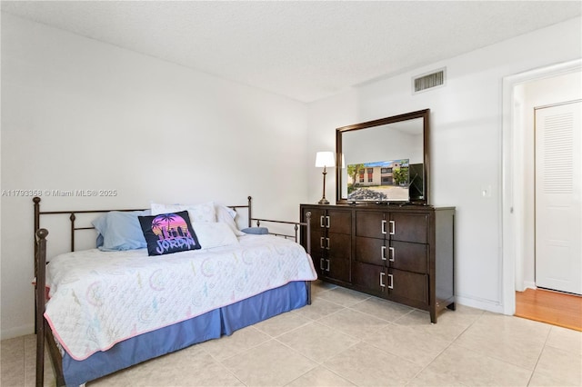bedroom with baseboards, light tile patterned flooring, and visible vents