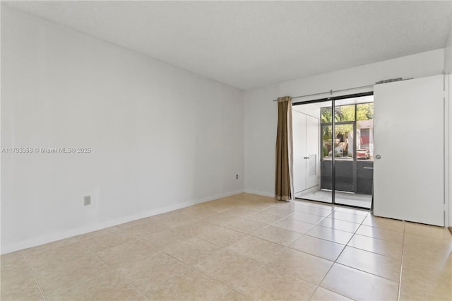 unfurnished room with baseboards and light tile patterned flooring