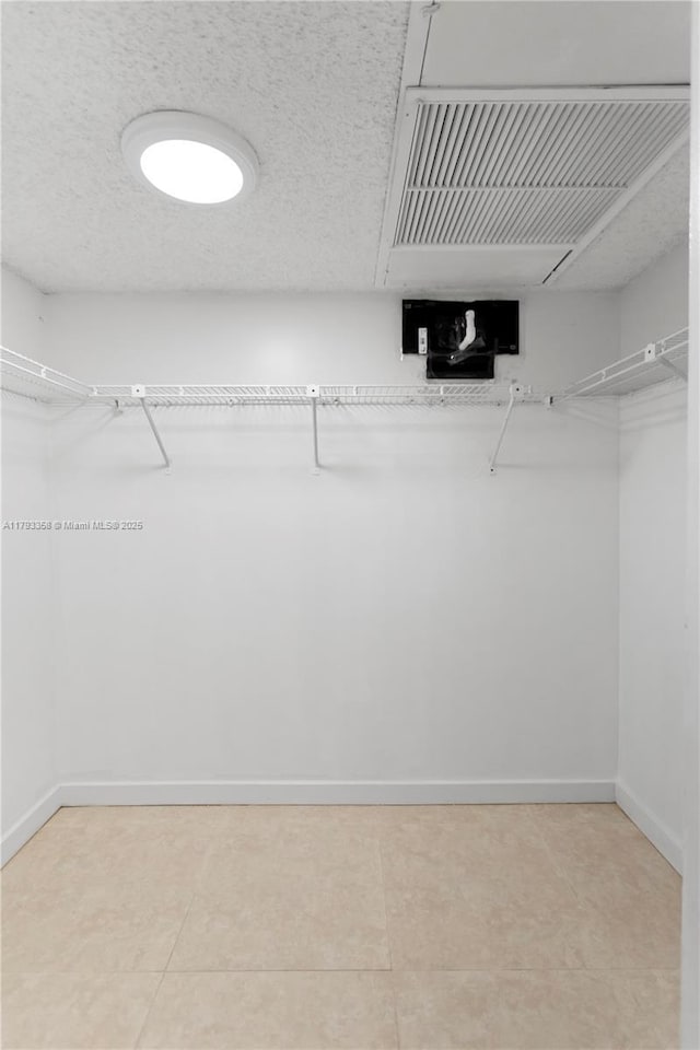 walk in closet featuring light tile patterned flooring