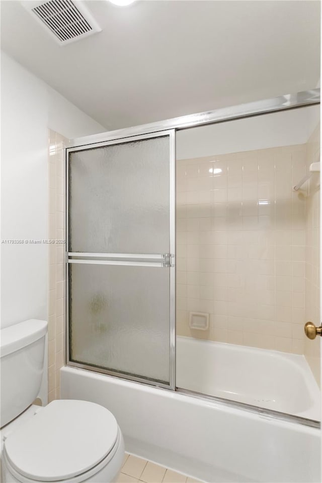 bathroom with tile patterned flooring, toilet, shower / bath combination with glass door, and visible vents