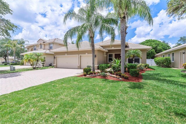 6017 NW 56th Cir, Coral Springs, FL 33067 - mediterranean / spanish-style home with stucco siding, driveway, a garage, and a tiled roof