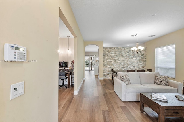 6017 NW 56th Cir, Coral Springs, FL 33067 - living area featuring wood finished floors, arched walkways, and a chandelier