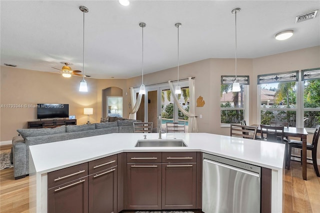6017 NW 56th Cir, Coral Springs, FL 33067 - kitchen featuring dishwasher, a sink, light wood finished floors, open floor plan, and light countertops