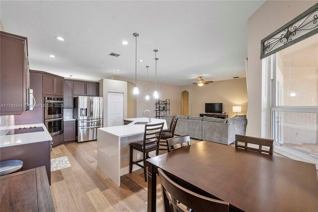 6017 NW 56th Cir, Coral Springs, FL 33067 - kitchen with stainless steel appliances, light countertops, light wood finished floors, arched walkways, and recessed lighting