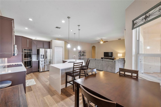 6017 NW 56th Cir, Coral Springs, FL 33067 - kitchen featuring stainless steel appliances, light wood-style flooring, light countertops, arched walkways, and recessed lighting