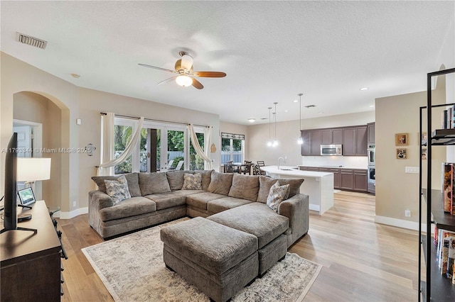 6017 NW 56th Cir, Coral Springs, FL 33067 - living room featuring ceiling fan, arched walkways, light wood-type flooring, recessed lighting, and a textured ceiling