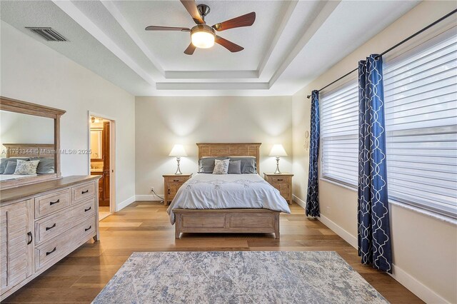 6017 NW 56th Cir, Coral Springs, FL 33067 - bedroom with a raised ceiling, wood finished floors, a ceiling fan, and ensuite bathroom