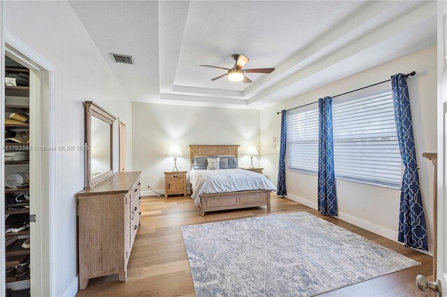 6017 NW 56th Cir, Coral Springs, FL 33067 - bedroom featuring a tray ceiling, light wood finished floors, and ceiling fan